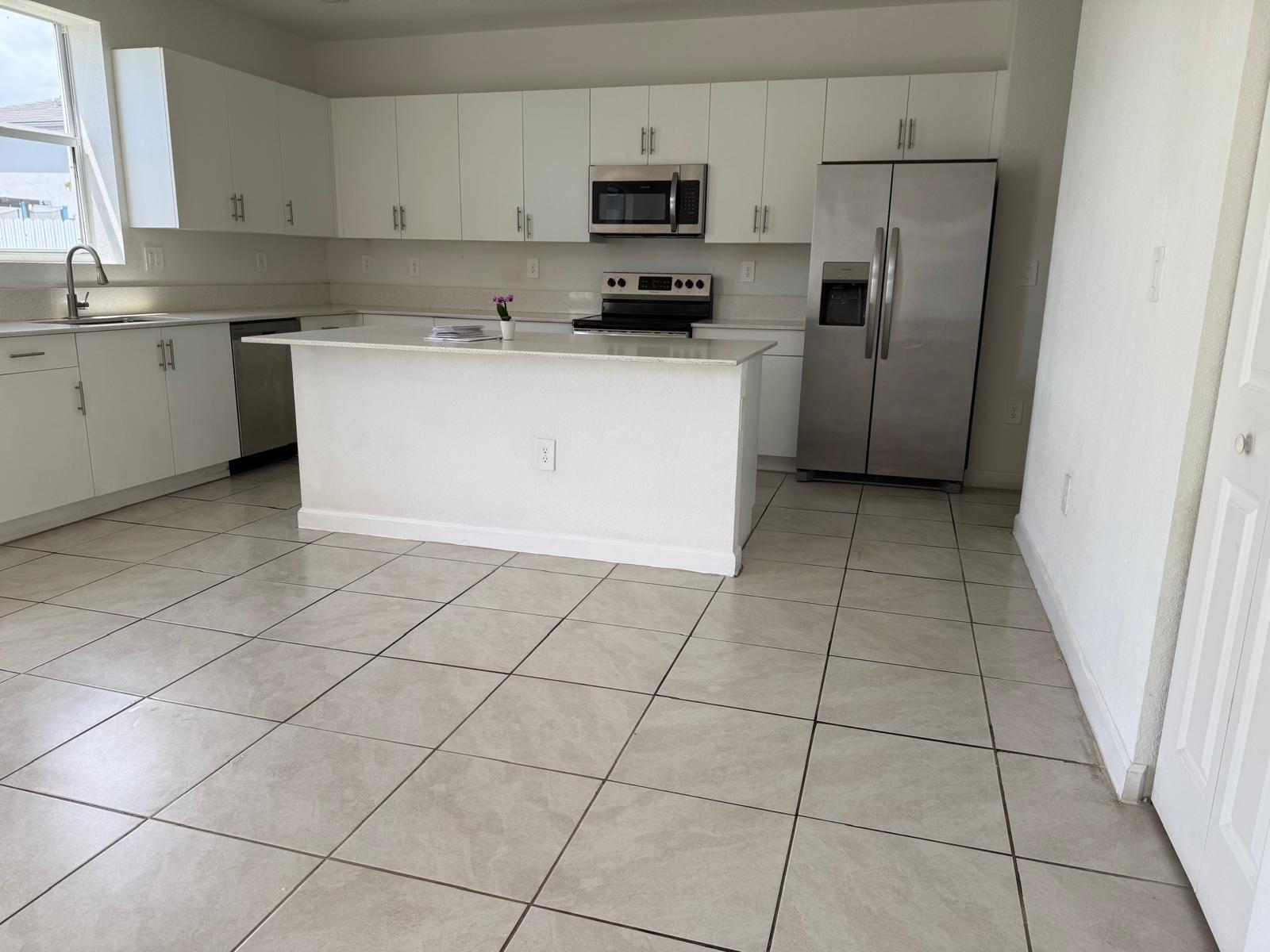 12736 Southwest 211th Street Miami, FL 33177 - Photo 5 of 18 a kitchen with stainless steel appliances cabinets a sink and a counter top space