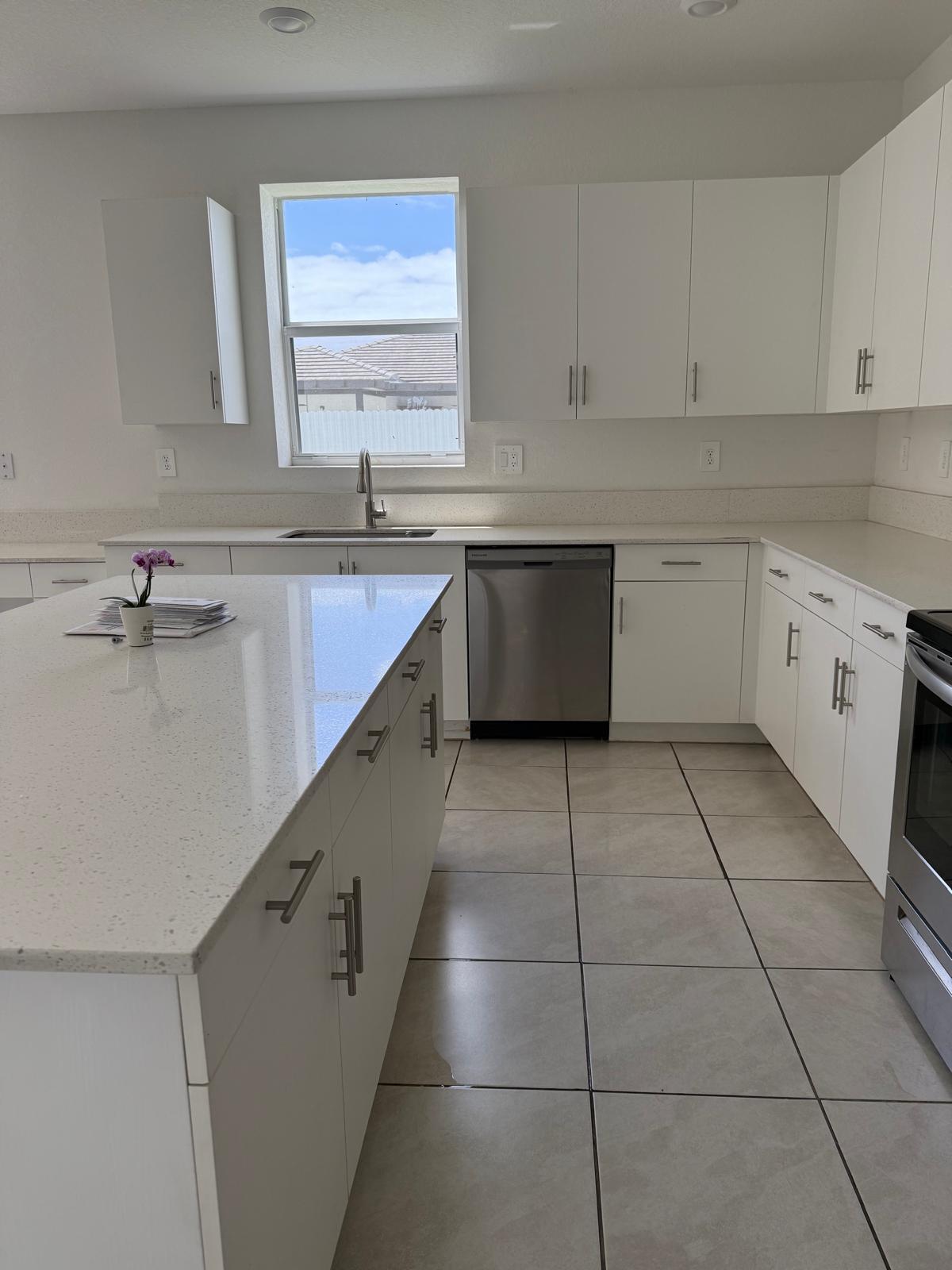 12736 Southwest 211th Street Miami, FL 33177 - Photo 6 of 18 a kitchen with a sink a stove cabinets and a window