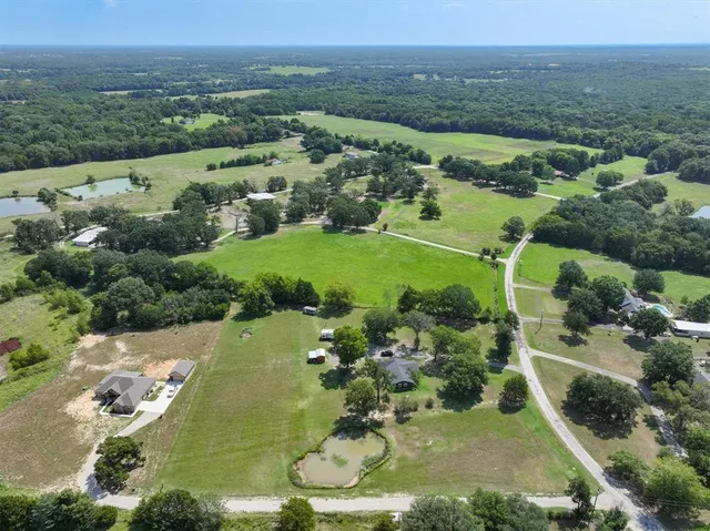 an aerial view of a houses with a yard