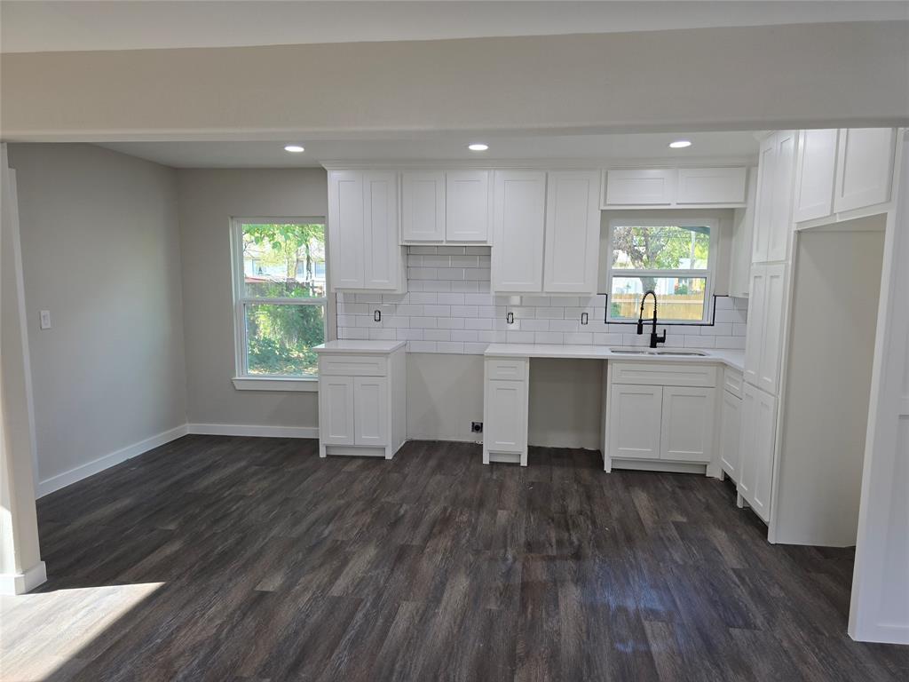 3107 51st Street Dallas, TX 75216 - Photo 2 of 4 Kitchen featuring white cabinets, recessed lighting, dark wood-style flooring, and backsplash