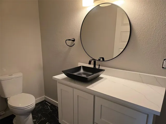 a bathroom with a toilet a sink and a mirror