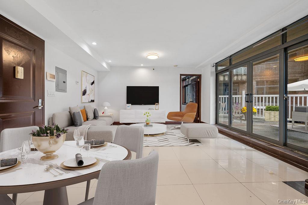 132-29 Blossom Avenue, Unit 2G Queens, NY 11355 - Photo 4 of 10 a living room with furniture and a flat screen tv