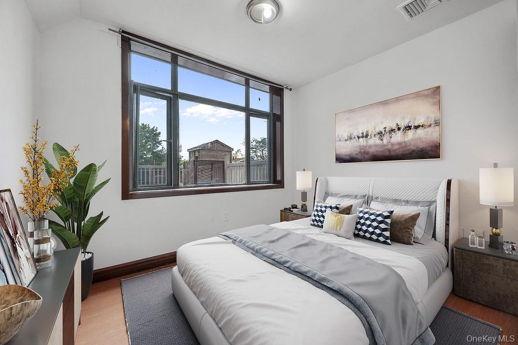 132-29 Blossom Avenue, Unit 2G Queens, NY 11355 - Photo 5 of 10 a bedroom with a large bed and a potted plant