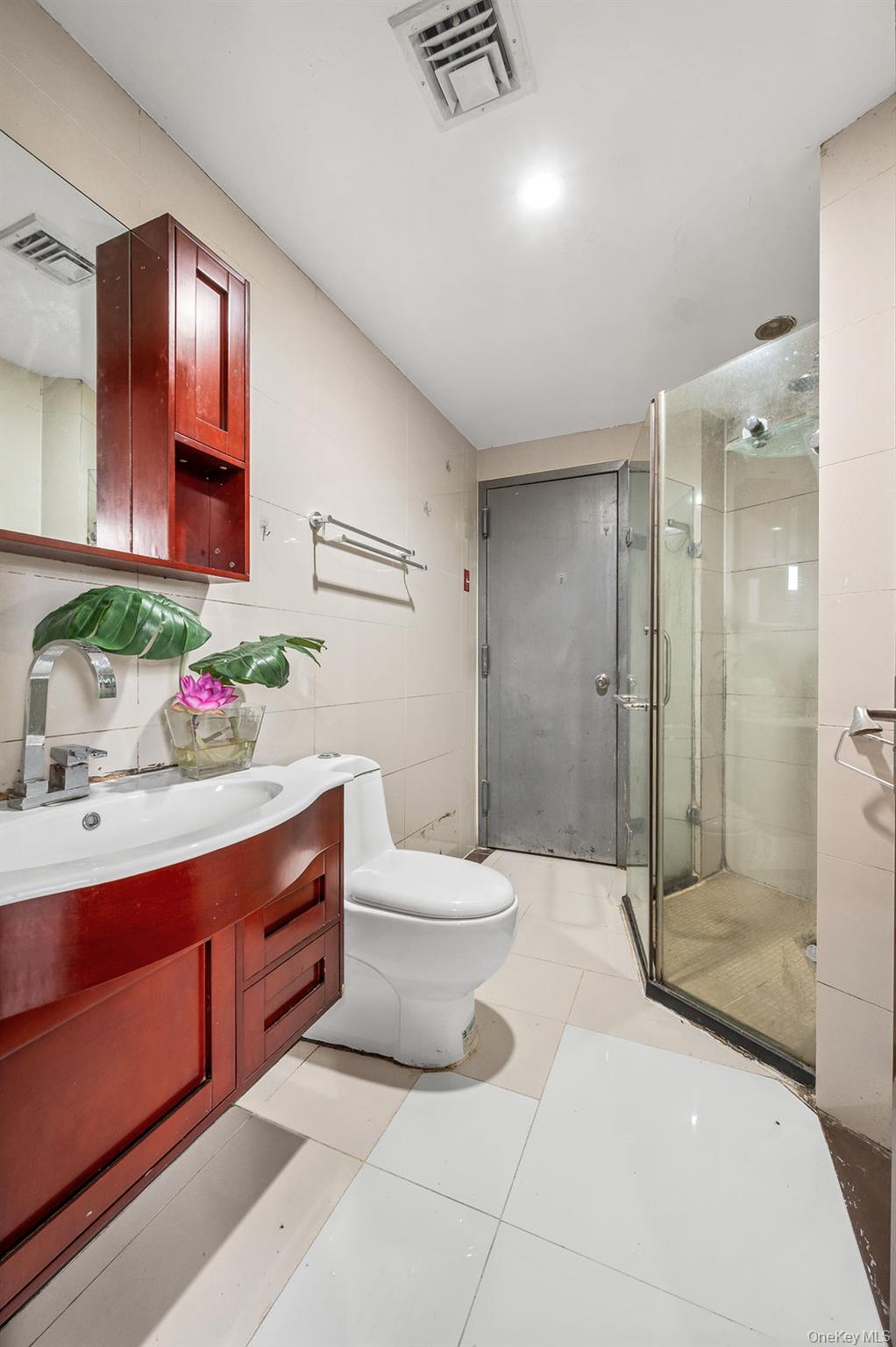 132-29 Blossom Avenue, Unit 2G Queens, NY 11355 - Photo 6 of 10 a bathroom with a sink mirror and shower