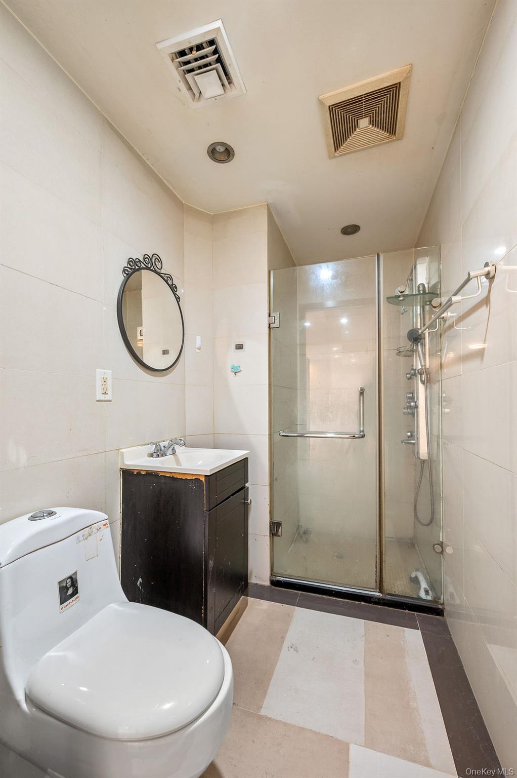 132-29 Blossom Avenue, Unit 2G Queens, NY 11355 - Photo 8 of 10 a bathroom with a toilet sink shower and mirror