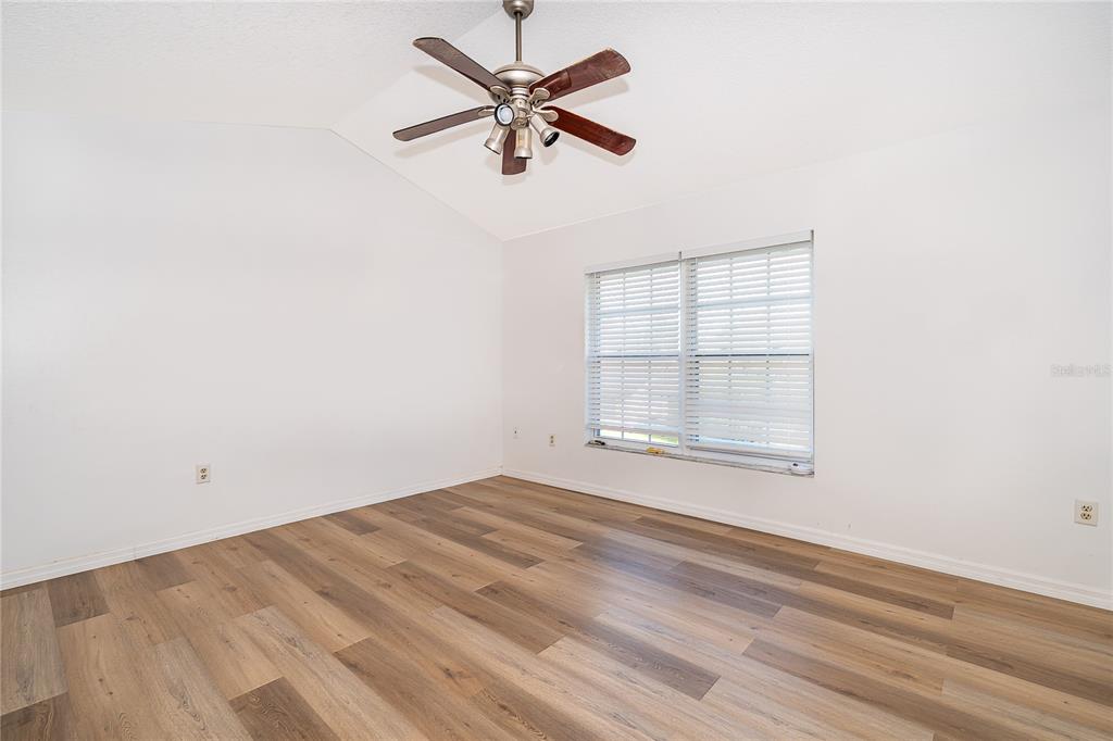 3135 Enclave Court Kissimmee, FL 34746 - Photo 19 of 22 an empty room with wooden floor fan and windows