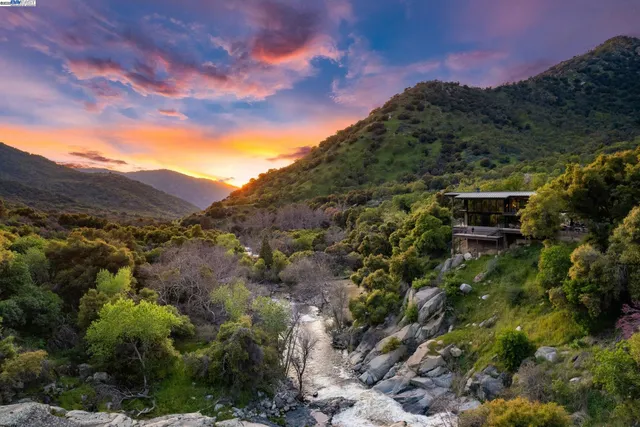 a view of a large building with mountains in the background