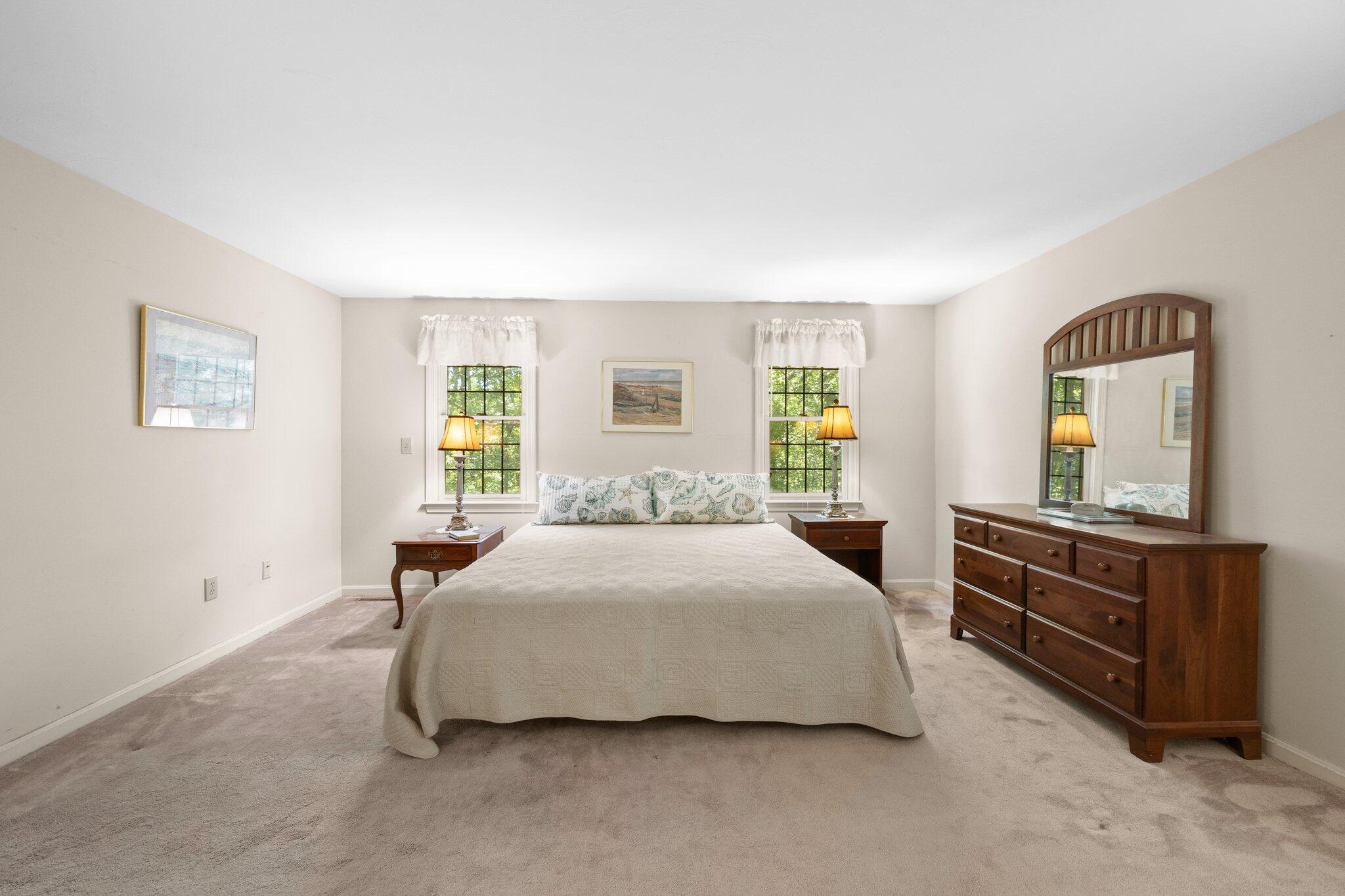 145 Braley Jenkins Road Centerville, MA 02632 - Photo 18 of 33 a bedroom with a bed and dresser with mirror