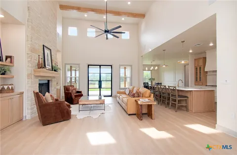 a living room with furniture a fireplace and a chandelier