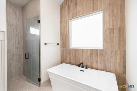a bathroom with a white bath tub sitting next to a white sink