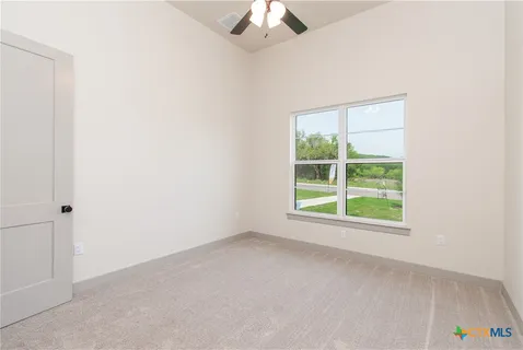 an empty room with a window and a fan
