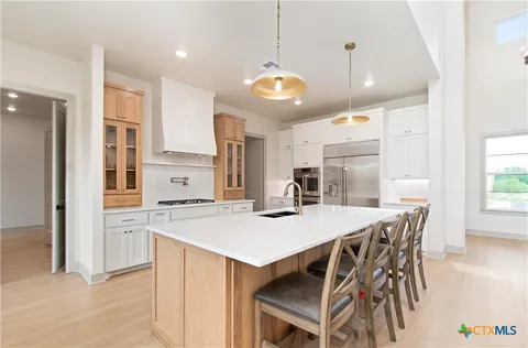 a kitchen with a table a refrigerator a stove a dining table and chairs