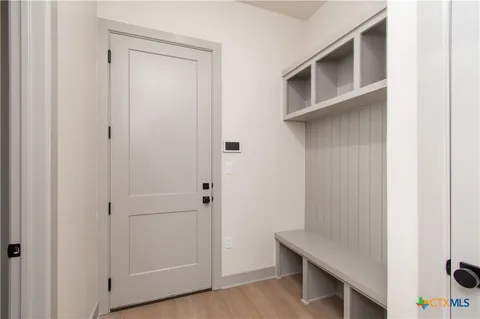 a view of cabinets and utility room with closet
