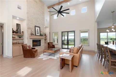 a living room with furniture a fireplace and a large window