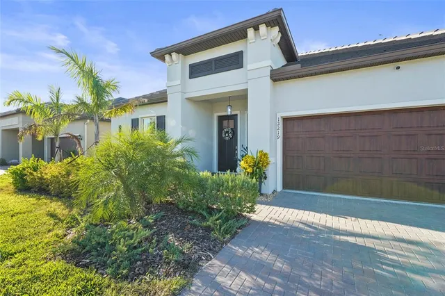 a large kitchen with stainless steel appliances a stove a sink dishwasher and a dining table with wooden floor