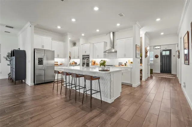 a utility room with stainless steel appliances and a wooden floor