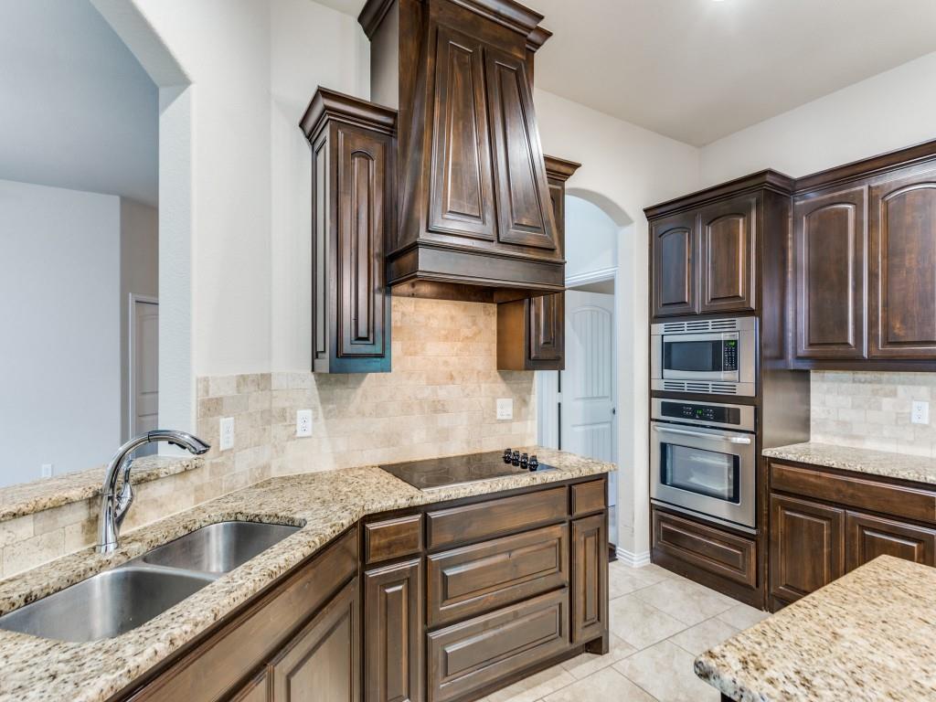 521 Corriente Trail Azle, TX 76020 - Photo 12 of 25 a kitchen with kitchen island granite countertop stainless steel appliances and cabinets