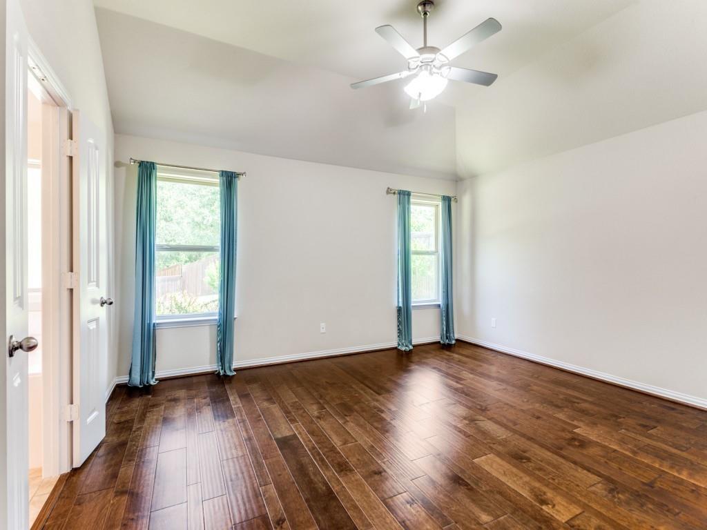 521 Corriente Trail Azle, TX 76020 - Photo 13 of 25 an empty room with wooden floor chandelier fan and windows