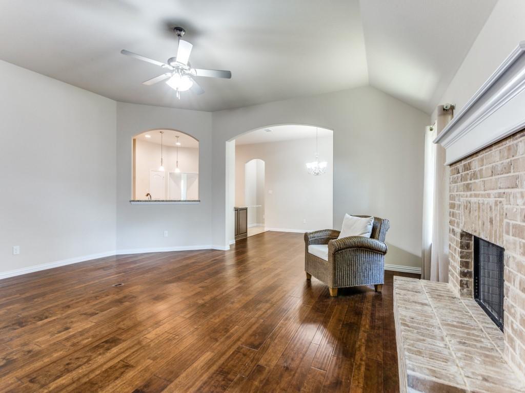 521 Corriente Trail Azle, TX 76020 - Photo 6 of 25 an empty room with wooden floor fireplace and dining table