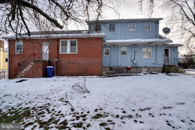 a view of a house with a yard covered with snow in front of house