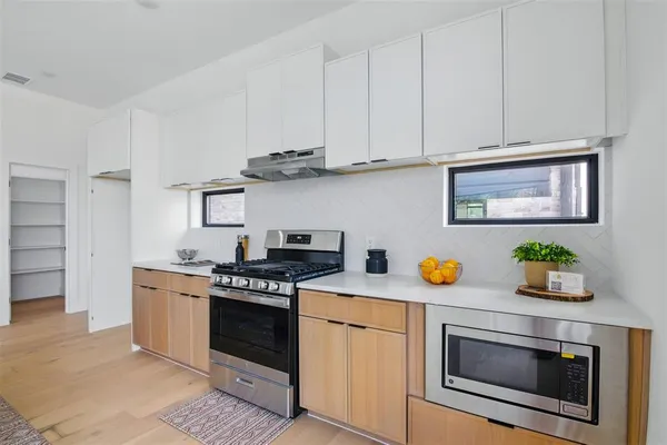 a kitchen with stainless steel appliances granite countertop a stove a microwave and cabinets