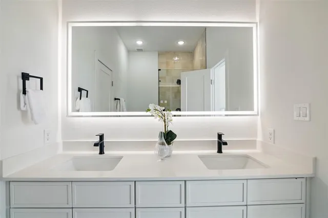 a bathroom with double vanity sink and mirror