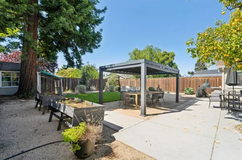 a view of a patio with couches table and chairs and potted plants