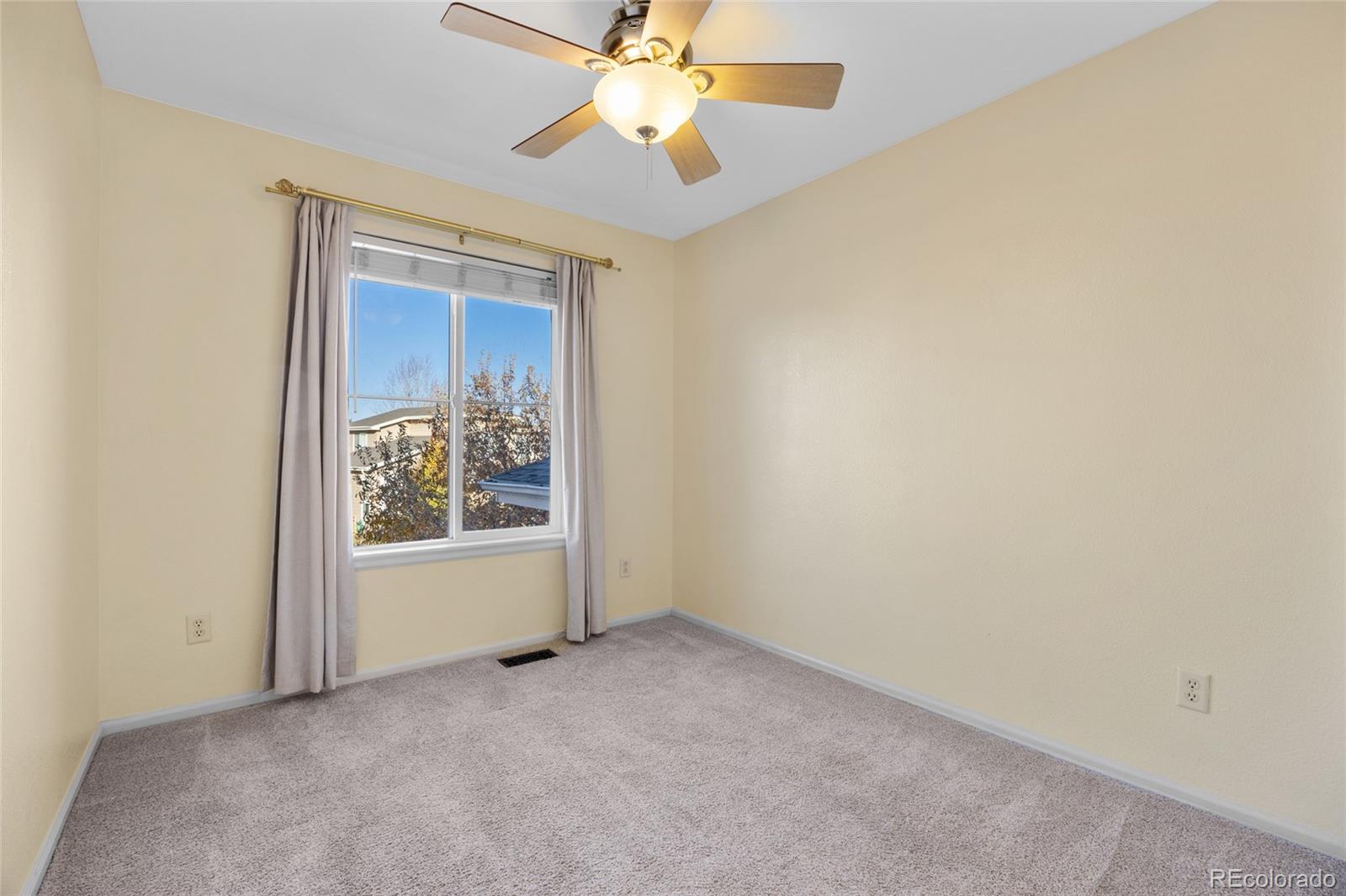 10655 Cherrybrook Circle Highlands Ranch, CO 80126 - Photo 23 of 42 an empty room with chandelier fan and windows