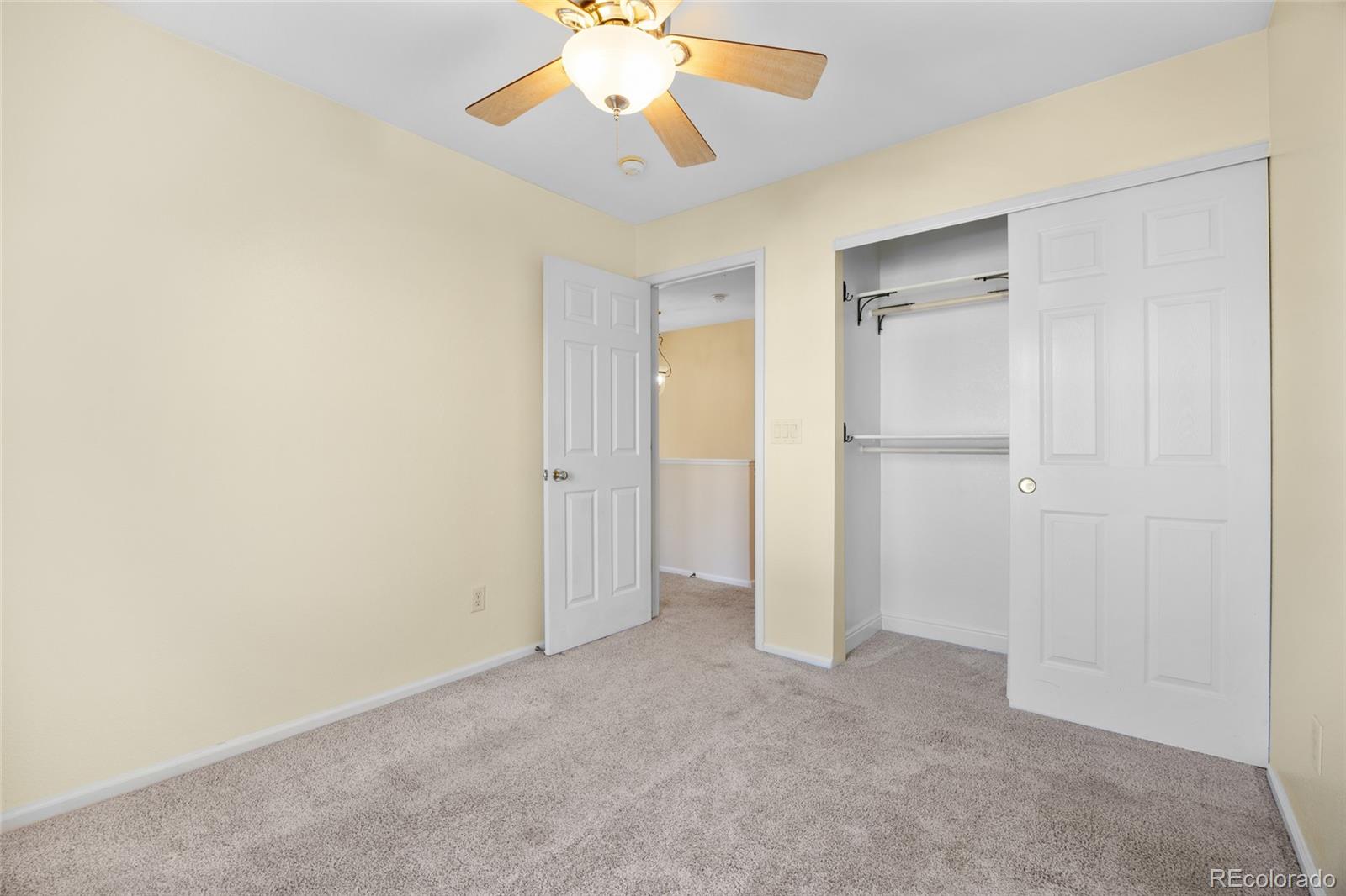 10655 Cherrybrook Circle Highlands Ranch, CO 80126 - Photo 24 of 42 an empty room with closet and a chandelier fan