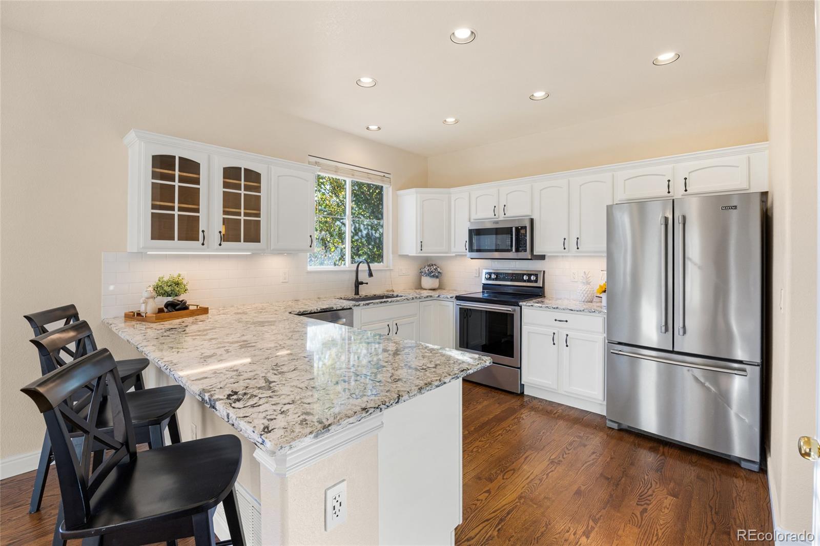 10655 Cherrybrook Circle Highlands Ranch, CO 80126 - Photo 8 of 42 a kitchen with granite countertop a refrigerator stove top oven dining table and chairs