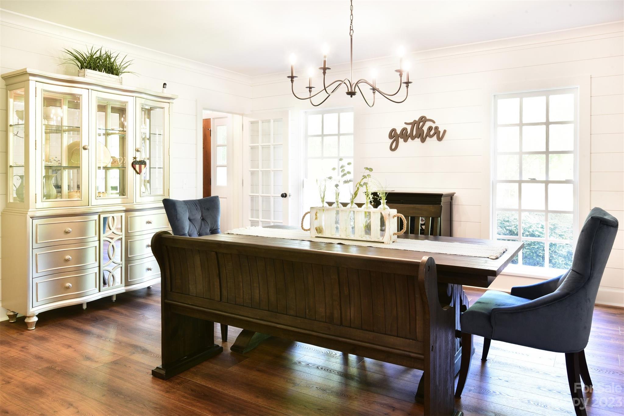 316 Biscoe Road Troy, NC 27371 - Photo 9 of 39 a dining room with wooden floor a chandelier a wooden table and chairs