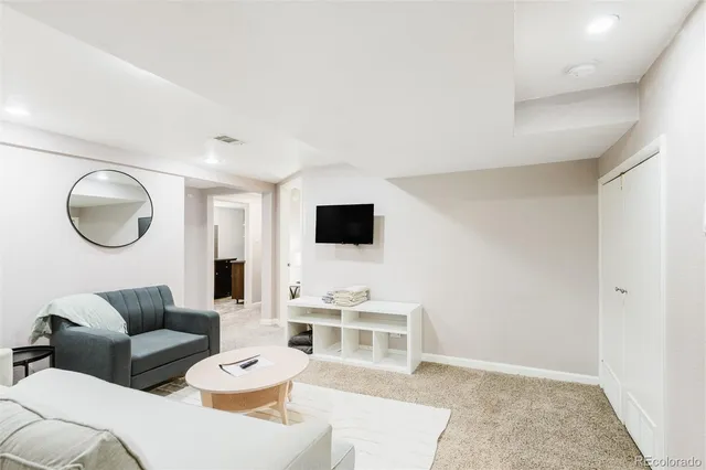 a living room with furniture a mirror and a flat screen tv