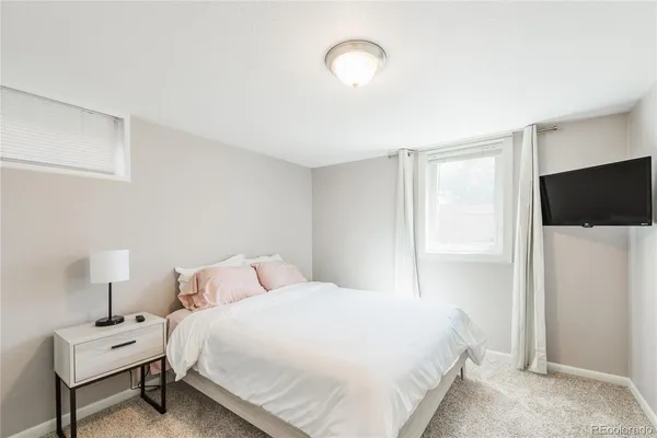 a bedroom with a bed tv and a window