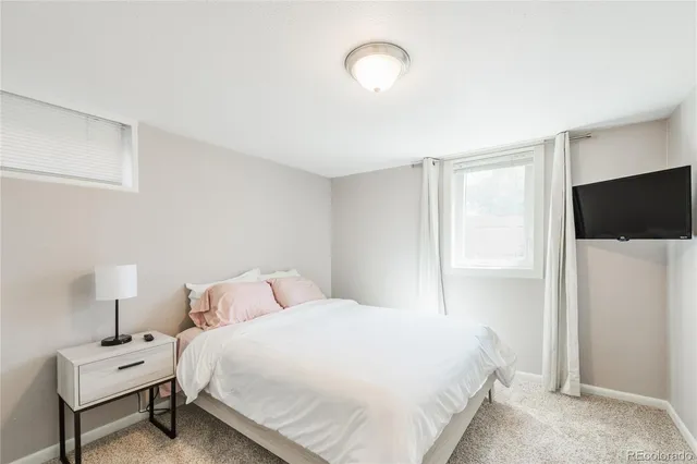 a bedroom with a bed tv and a window