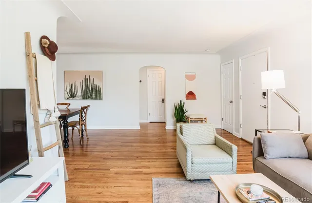 a living room with furniture and a wooden floor