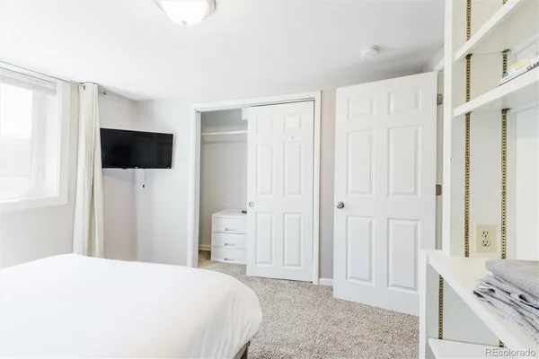 a bedroom with a bed and a flat screen tv