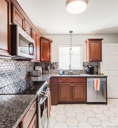 a kitchen with stainless steel appliances granite countertop a sink stove and cabinets