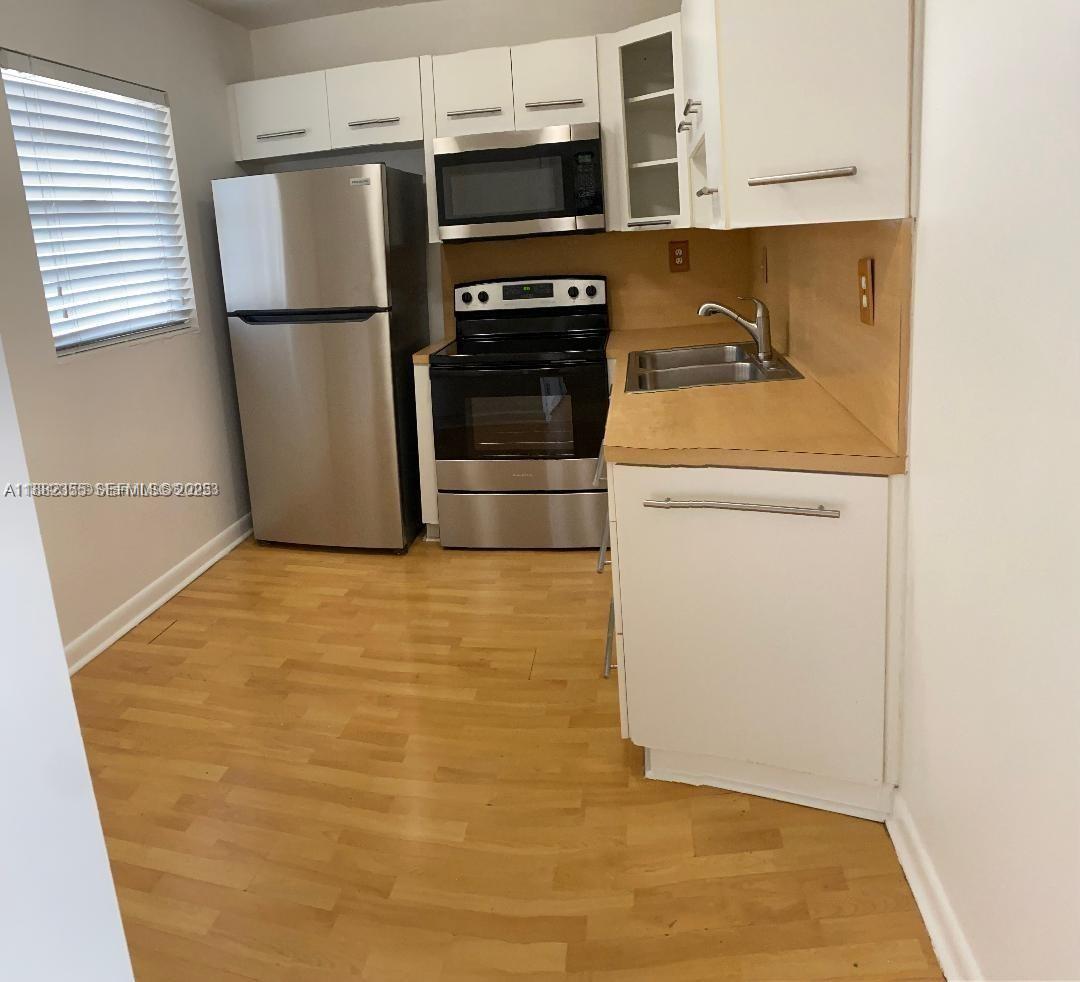 7725 Southwest 86th Street, Unit A1421 Miami, FL 33143 - Photo 6 of 6 a kitchen with a refrigerator and a stove