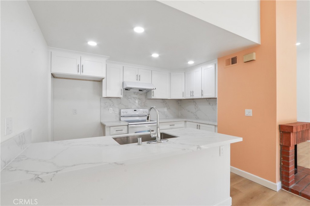 22 Fabriano Irvine, CA 92620 - Photo 10 of 20 a kitchen with a sink a stove a refrigerator and white cabinets