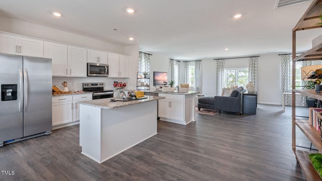 a kitchen with stainless steel appliances granite countertop a stove and a wooden floors
