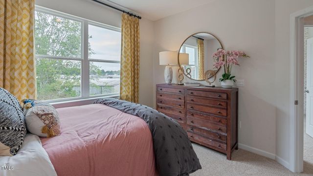 a bedroom with a bed and a lamp on dresser