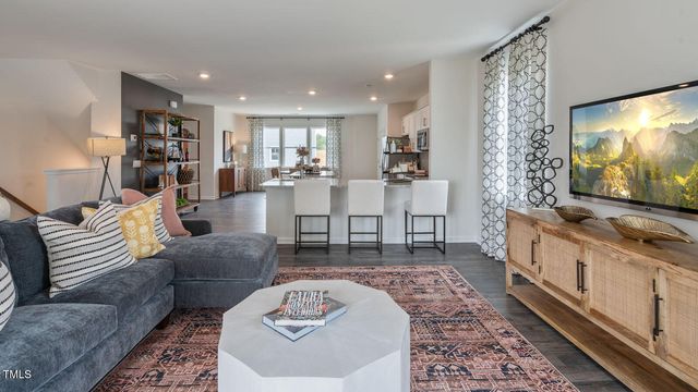 a living room with furniture a rug and a lamp