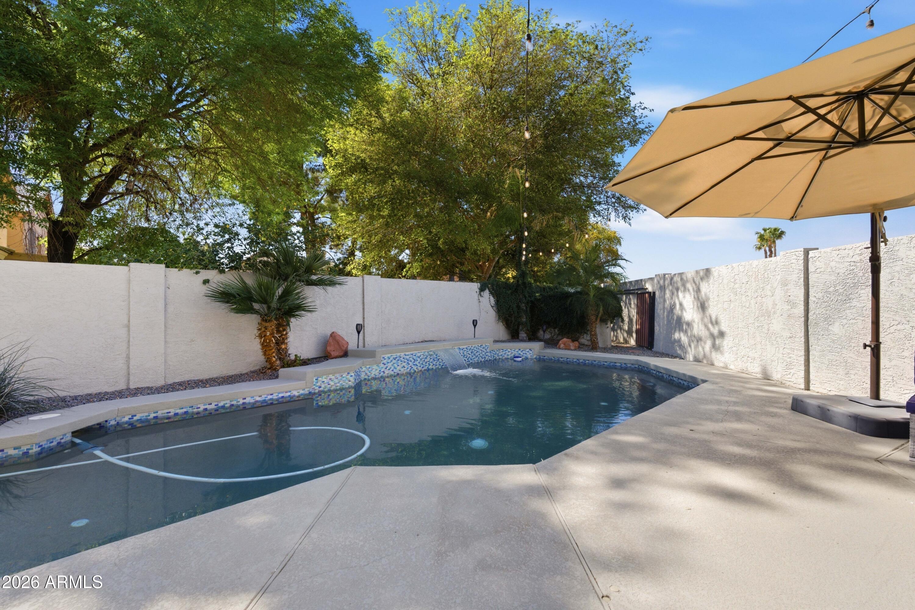 418 South Burk Street Gilbert, AZ 85296 - Photo 62 of 90 a view of a backyard with a sink and table under an umbrella