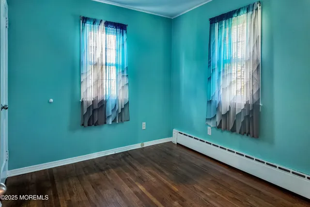an empty room with wooden floor and a window