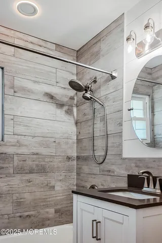 a bathroom with a granite countertop sink a vanity and shower