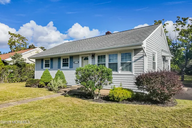 a front view of a house with a yard and outdoor seating