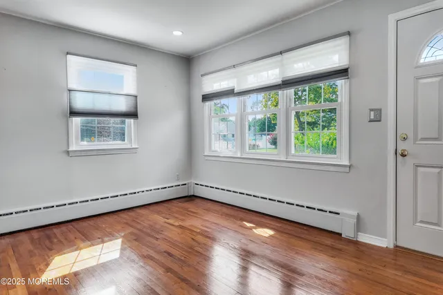 a view of a room with wooden floor and a window