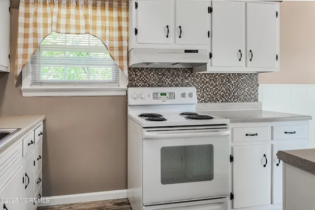 a stove top oven sitting inside of a kitchen