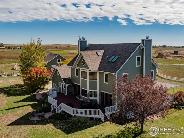 an aerial view of a house with swimming pool and outdoor seating
