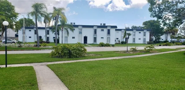 a view of a big building with a big yard and plants